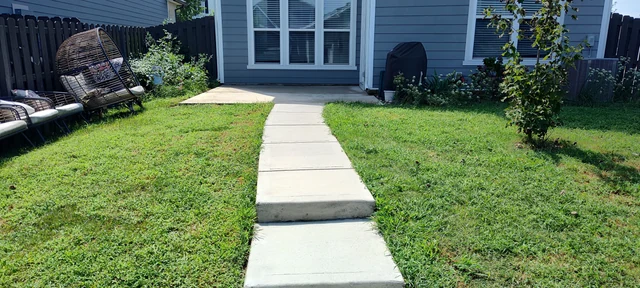 Clean backyard concrete walkway and patio area after pressure washing in Pineville, NC.
